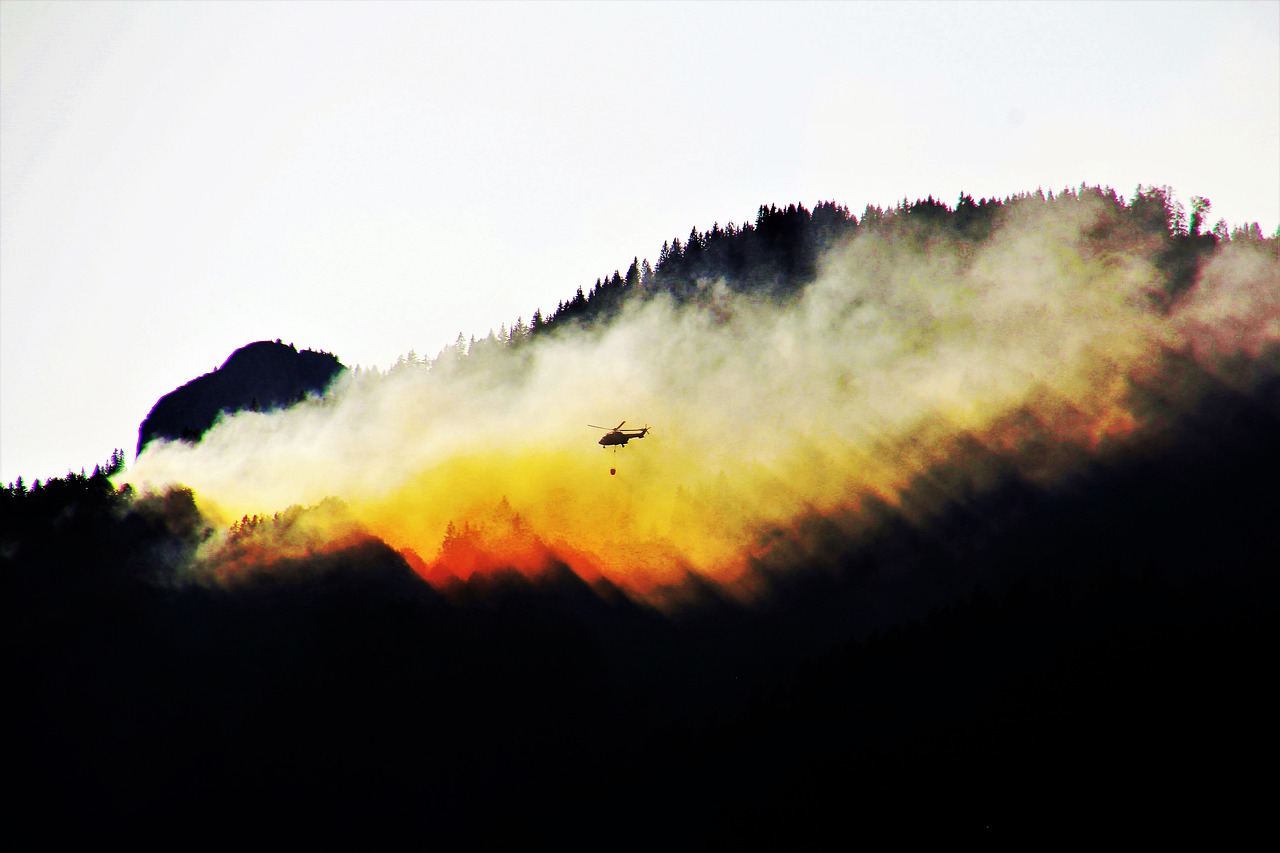 Helikopter som släpper vatten på en skogsbrand